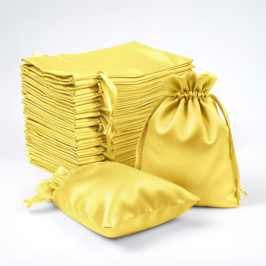 Yellow satin drawstring bags stacked and displayed in various sizes.