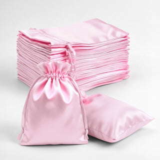Pink satin drawstring bags stacked on a white background.