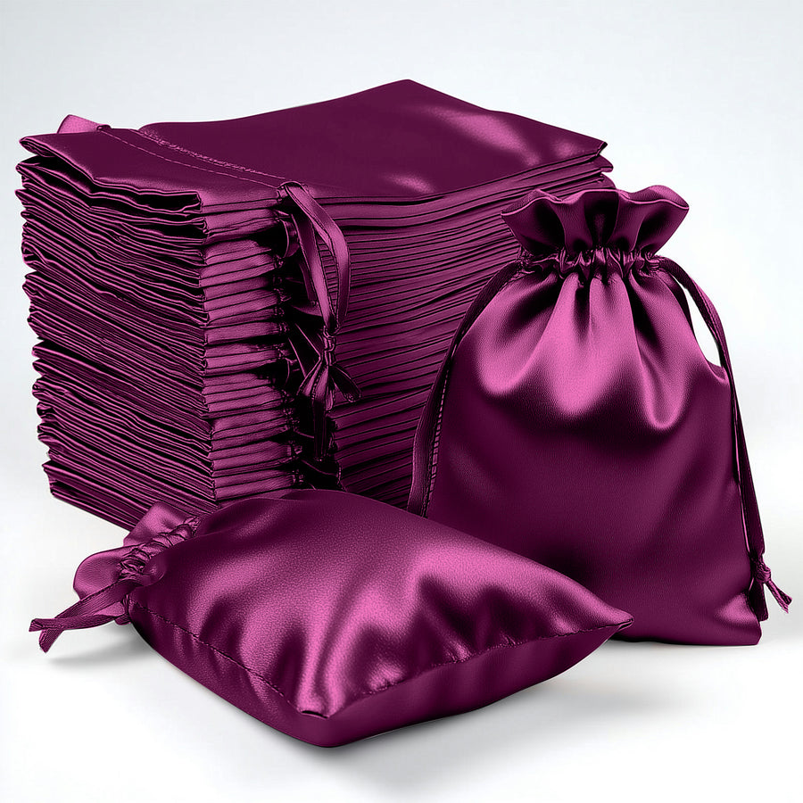 Stack of purple satin drawstring bags in various sizes on a plain background