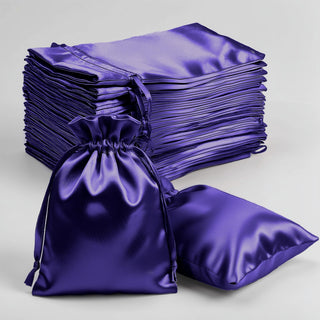 Set of purple satin drawstring bags and cushions on a white background.