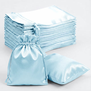 Light blue satin bags and fabric stacks on a plain background.