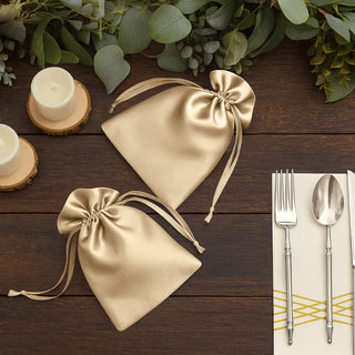 Elegant gold satin favor bags on a rustic wooden table.