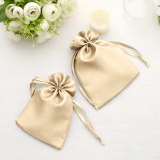 Gold satin drawstring bags on a light background.