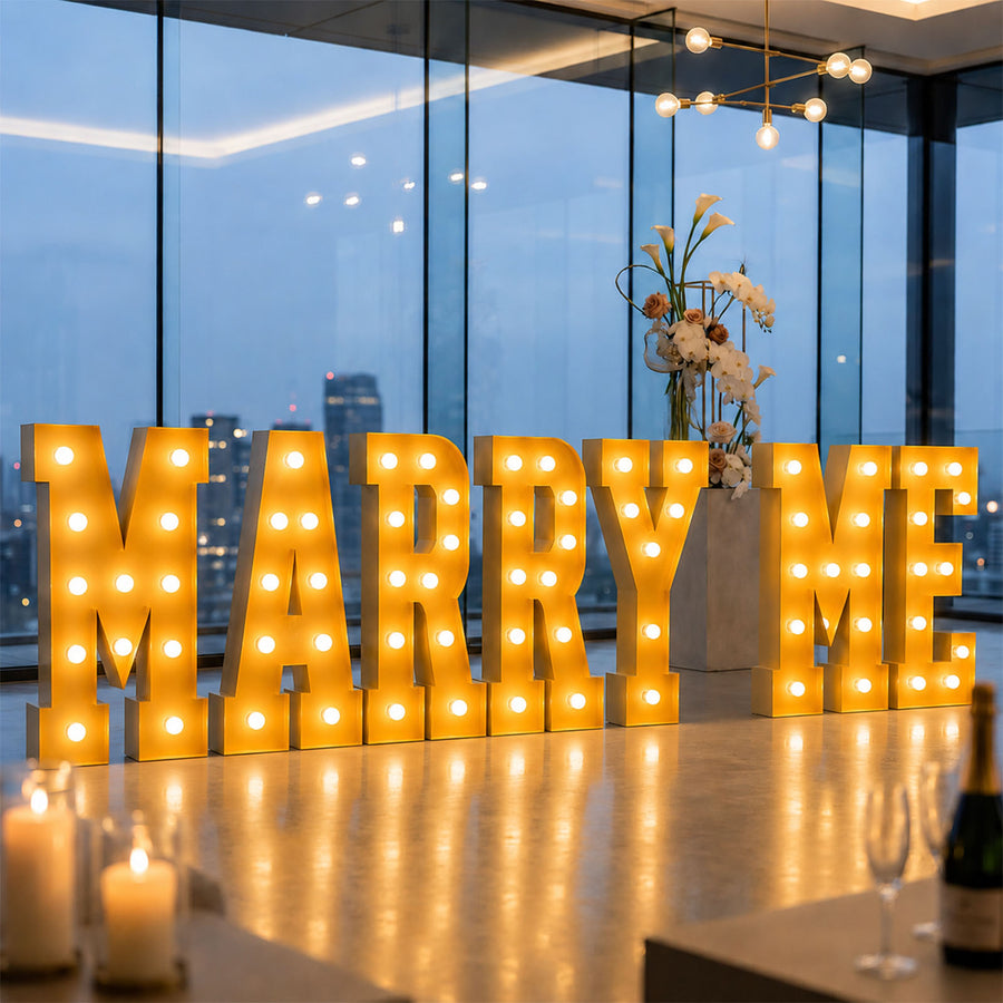 Illuminated “MARRY ME” proposal sign in modern luxury wedding venue