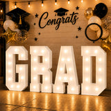 Graduation party backdrop with illuminated "GRAD" letters and balloons