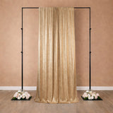 Gold sequin backdrop with black frame and floral arrangements at the base.