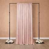 Rose gold sequin backdrop on a stand with floral arrangements.
