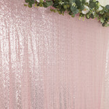 Pink sequin backdrop with greenery accents for events and photo shoots.