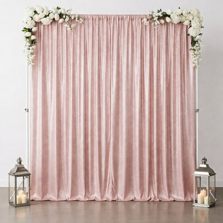 Pink sequin backdrop with floral accents and lanterns for events or photo shoots.