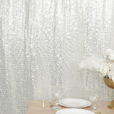 Elegant silver sequin table backdrop with decorative plates and glassware. #whtbkgd