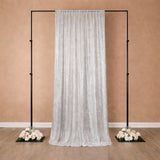 Silver sequin backdrop with floral arrangements on a stand.