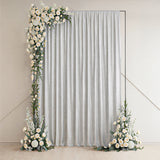 Elegant silver curtain with floral accents on either side.