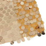 Gold sequin fabric close-up on sheer mesh background