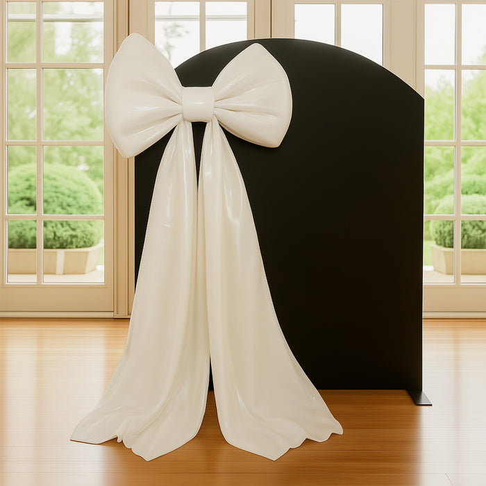 White decorative bow sculpture on a black backdrop.