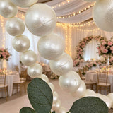Elegant pearl balloon arch at a luxury wedding reception with fairy lights