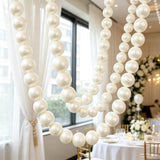 Elegant white pearl balloon garland wedding decor in a bright venue