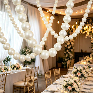 Elegant wedding reception with white balloon garlands and floral table centerpieces