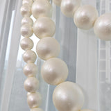 Cream pearl foam balls hanging in a soft white window garland decor
