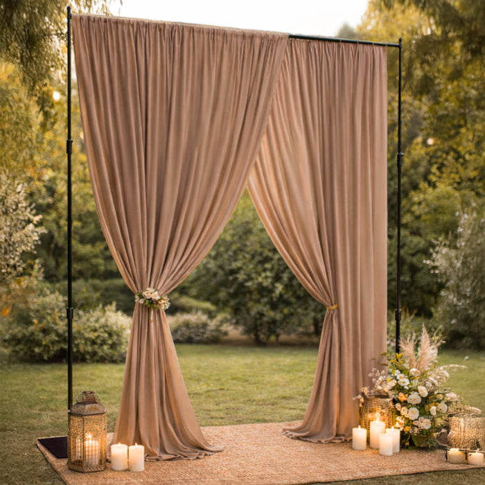 Elegant beige drapery with lanterns and candles for outdoor event decor.