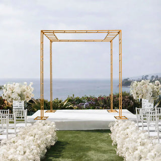 Gold wedding arch set against a scenic ocean view backdrop.