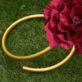 Gold garden hose with red flower on grass