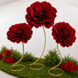Red floral arrangement with large decorative blooms on gold stems