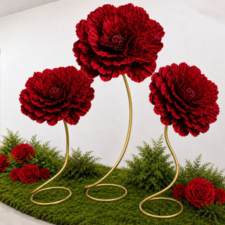 Red floral arrangement with large decorative blooms on gold stems