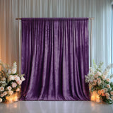 Purple velvet backdrop with floral arrangements and candles for events.