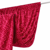Velvet curtain in rich red color, draped elegantly on a white rod.