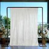 Elegant white backdrop draped on a gold frame with floral arrangements.