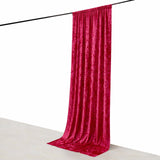 Red velvet curtain draped elegantly on a rod against a plain backdrop