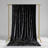 Black velvet curtain on gold clothing rack in minimalist studio setting