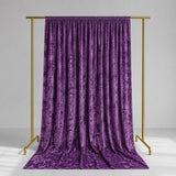Purple velvet curtain on gold clothing rack against a gray studio background
