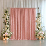Pink wedding backdrop with floral arrangements and candles
