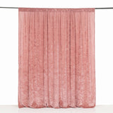 Pink velvet curtain panel hanging on a rod against a white background