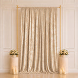 Elegant gold wedding backdrop with champagne curtains, floral arrangements, and candles