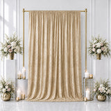 Elegant gold wedding backdrop with beige drapes, floral arrangements, and candles