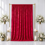 Red velvet backdrop with gold frame, white floral arrangements, and candles