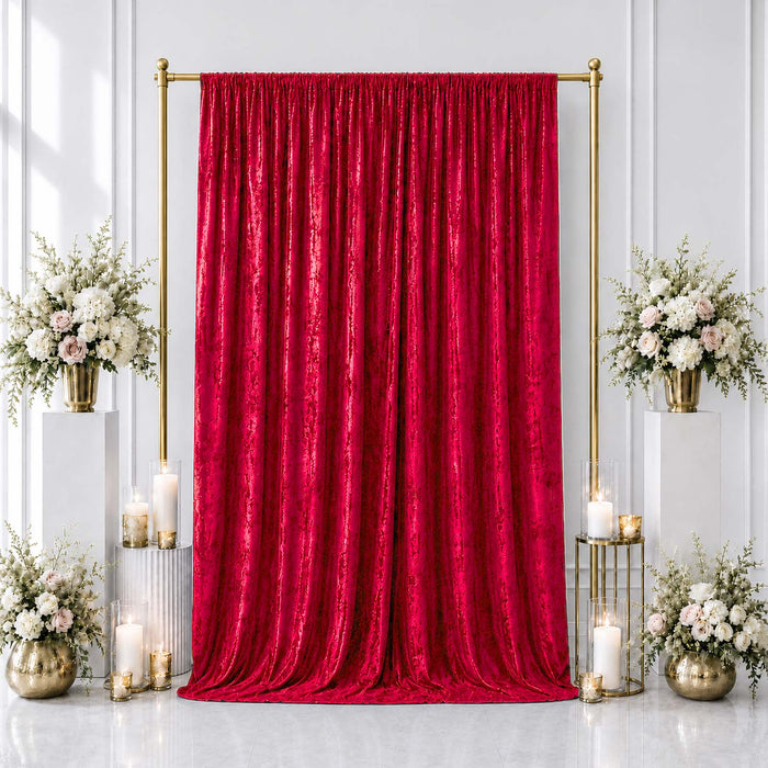 Red velvet backdrop with gold frame, white floral arrangements, and candles