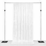 White patterned backdrop curtain on adjustable metal stand with weighted bases