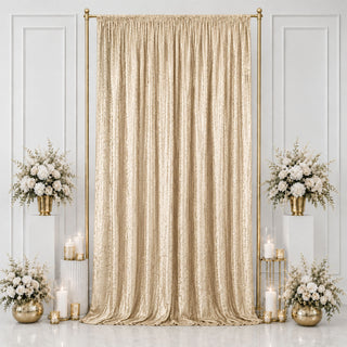 Gold wedding backdrop with champagne drape, white flowers, and candles