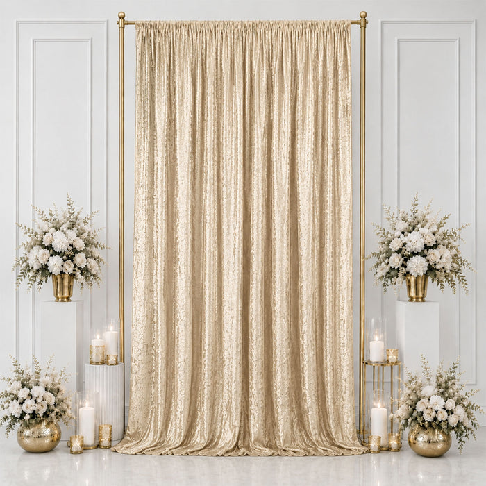 Gold wedding backdrop with champagne drape, white flowers, and candles