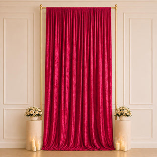 Elegant red velvet backdrop with gold frame, floral pedestals, and candles