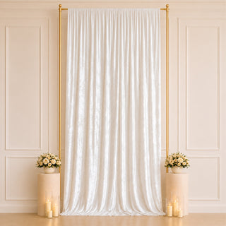 Elegant white wedding backdrop with gold frame, floral arrangements, and candles
