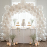 Elegant dessert table with balloons, cake, and flowers for a celebration. #whtbkgd