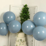 Blue balloons arranged with a wedding cake and greenery backdrop.