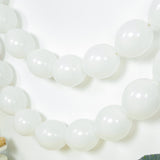 White balloon garland decoration on a plain background