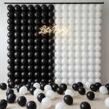 Black and white balloon backdrop with neon "Let's Party" sign.
