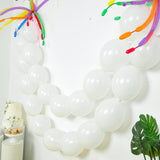 White balloons arranged in a festive arch for celebrations.