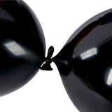 Two black balloons tied together on a white background